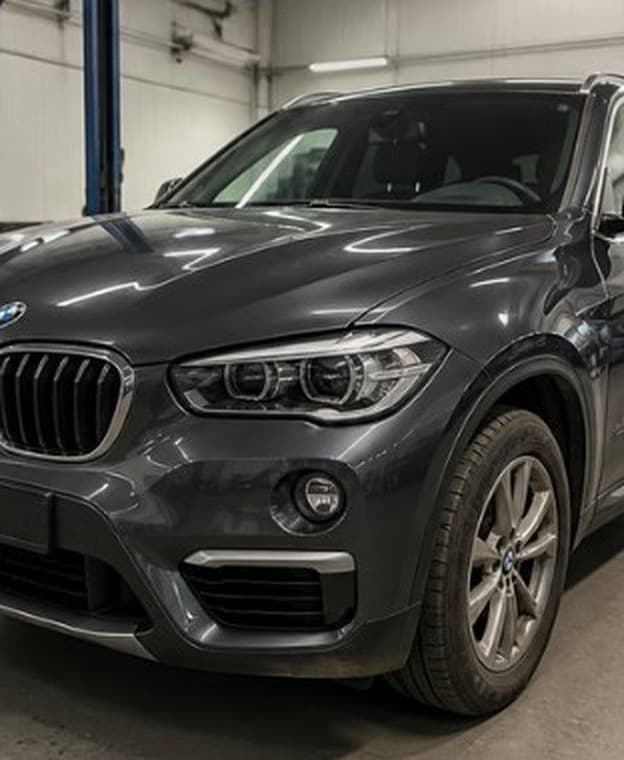 Dark SUV with front bumper and fender damage, after repair