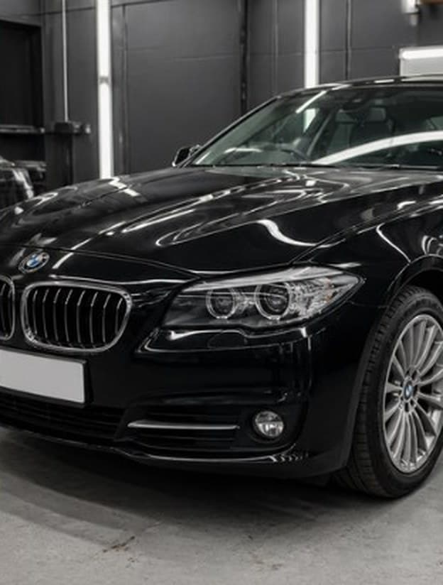 Black sedan with front-end damage, after repair